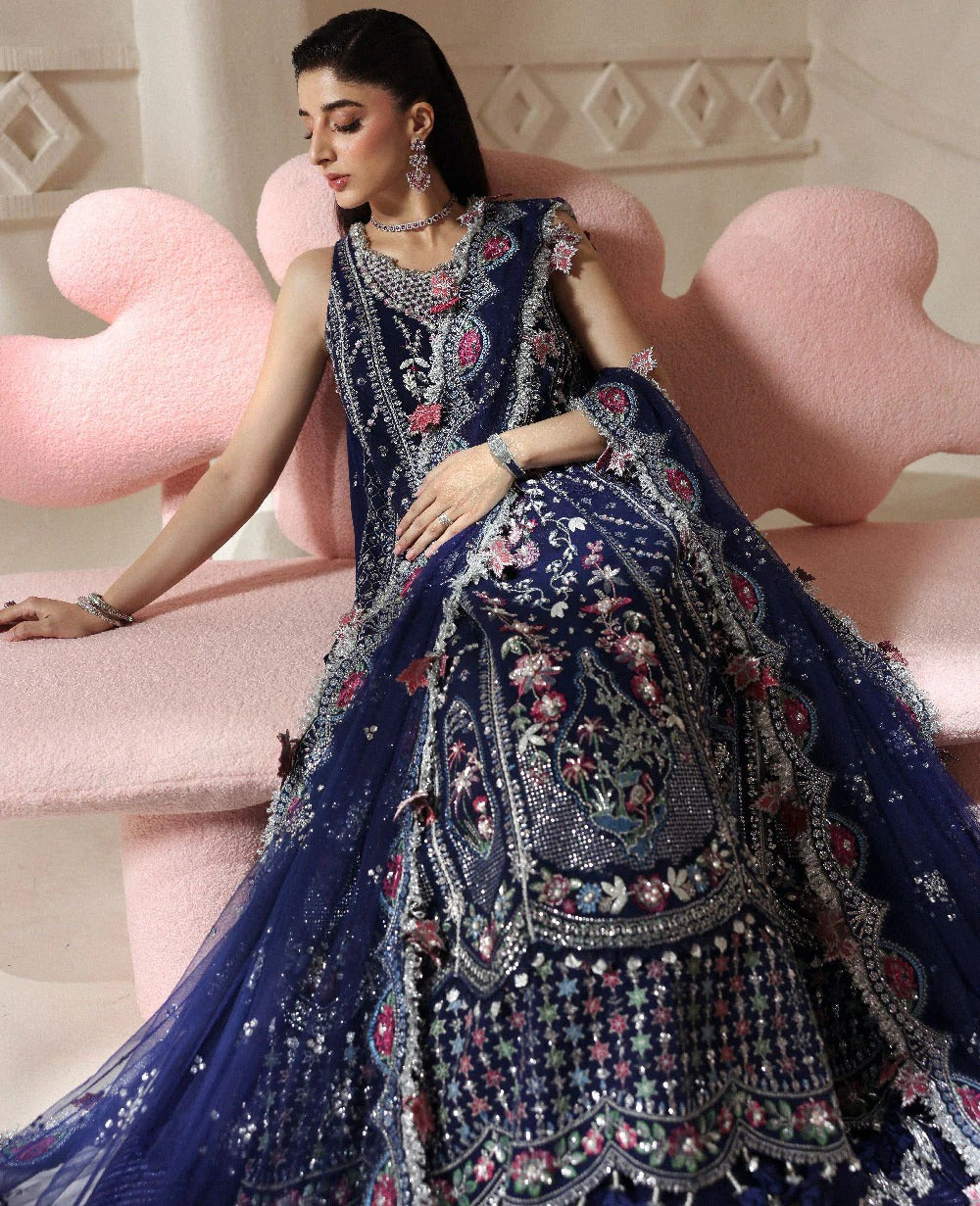 Discover elegance in this paneled net gown featuring classic shikargah motifs, shimmering sequins, scalloped hem, and an ethereal dupatta for timeless grace.