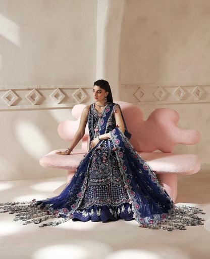 Discover elegance in this paneled net gown featuring classic shikargah motifs, shimmering sequins, scalloped hem, and an ethereal dupatta for timeless grace.