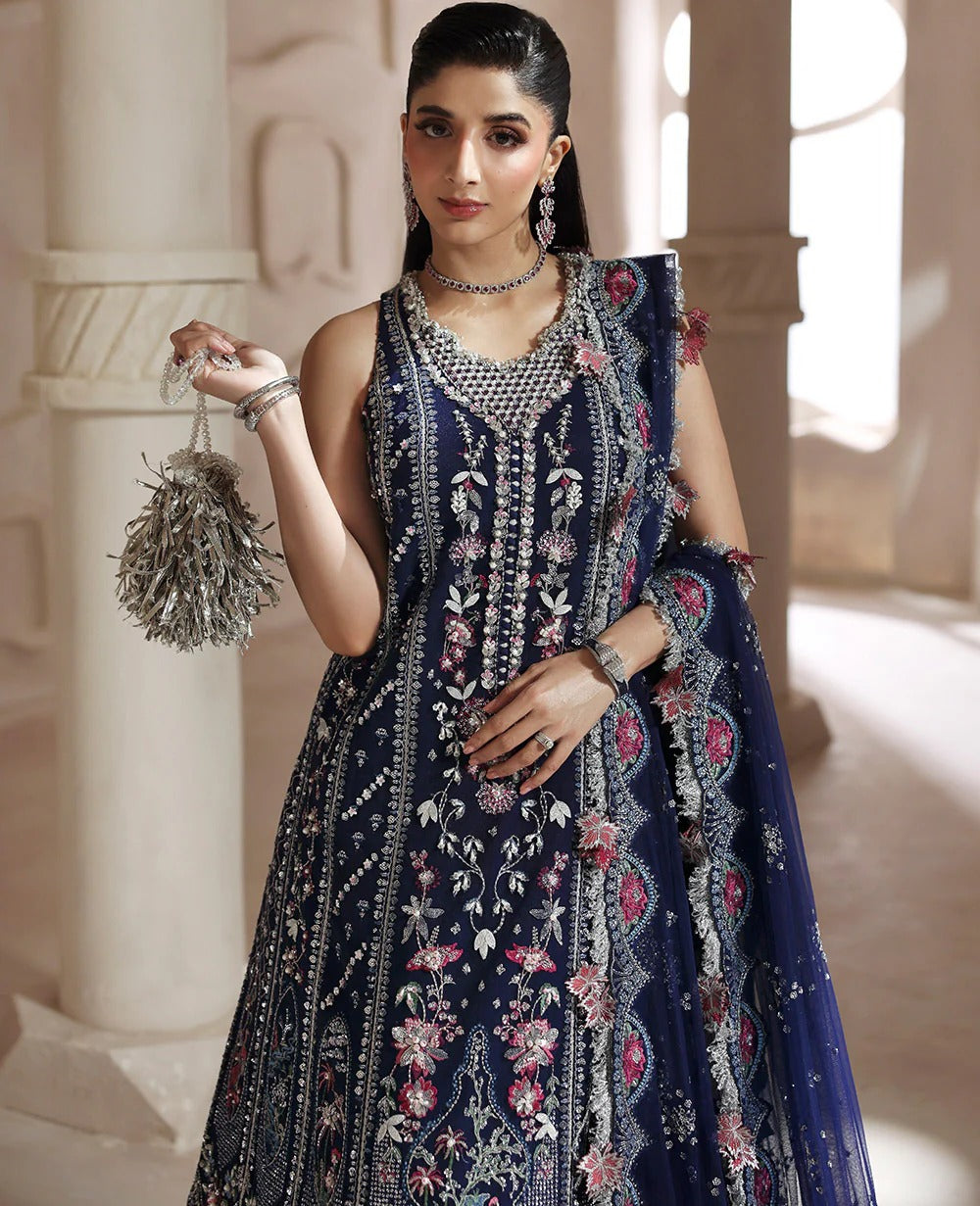Discover elegance in this paneled net gown featuring classic shikargah motifs, shimmering sequins, scalloped hem, and an ethereal dupatta for timeless grace.