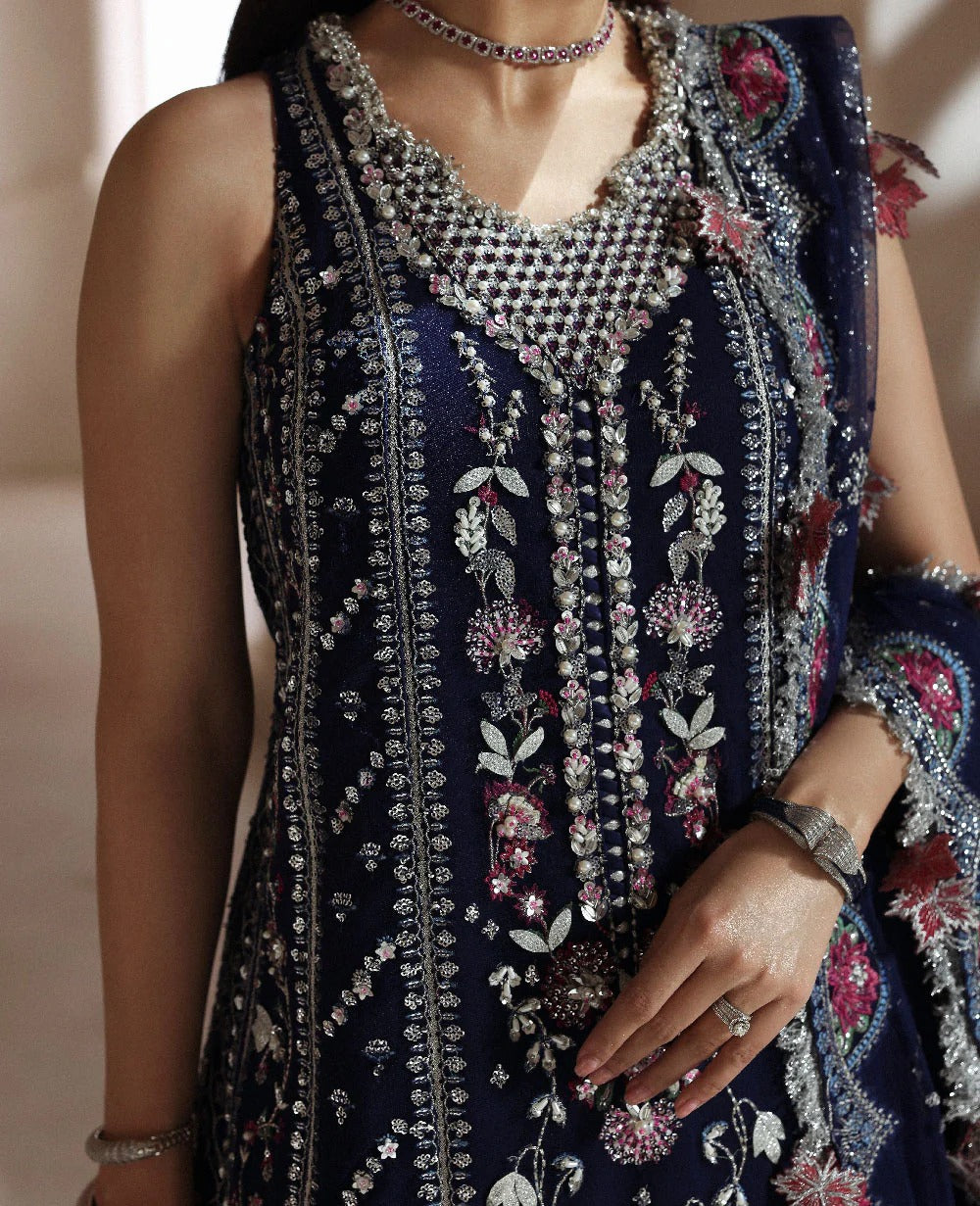Discover elegance in this paneled net gown featuring classic shikargah motifs, shimmering sequins, scalloped hem, and an ethereal dupatta for timeless grace.