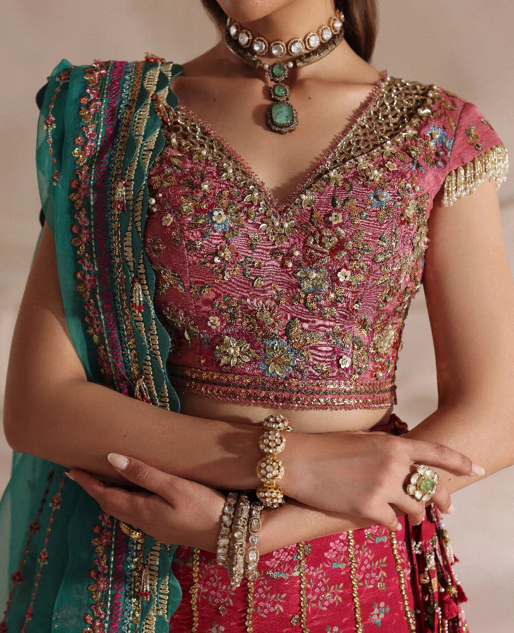 Radiant hot pink raw silk lehenga with a shikargah blouse, golden adda work, and teal embroidered dupatta — a bold, regal blend of color, craft, and heritage.