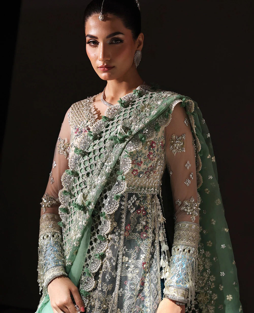 Ethereal white net shirt with blush florals, sequin accents, and a sage dupatta paired with a green lehenga — a perfect blend of grace, charm, and celebration