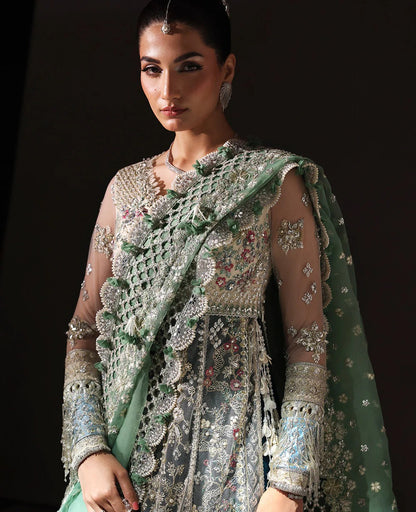 Ethereal white net shirt with blush florals, sequin accents, and a sage dupatta paired with a green lehenga — a perfect blend of grace, charm, and celebration