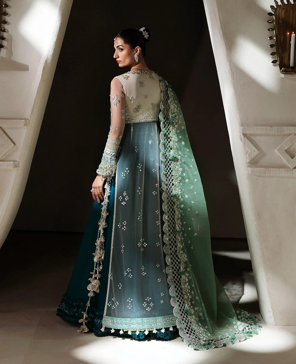 Ethereal white net shirt with blush florals, sequin accents, and a sage dupatta paired with a green lehenga — a perfect blend of grace, charm, and celebration