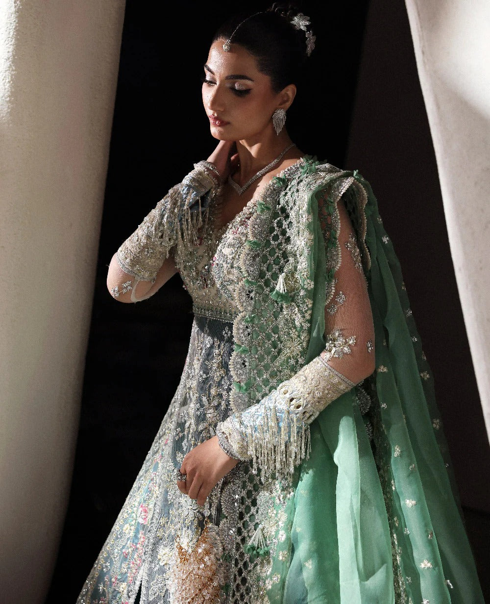 Ethereal white net shirt with blush florals, sequin accents, and a sage dupatta paired with a green lehenga — a perfect blend of grace, charm, and celebration