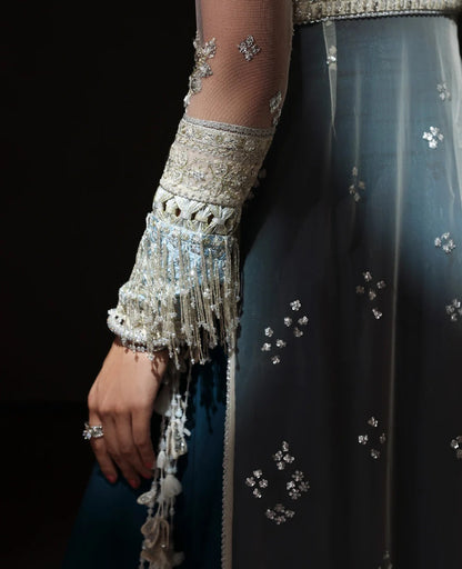 Ethereal white net shirt with blush florals, sequin accents, and a sage dupatta paired with a green lehenga — a perfect blend of grace, charm, and celebration