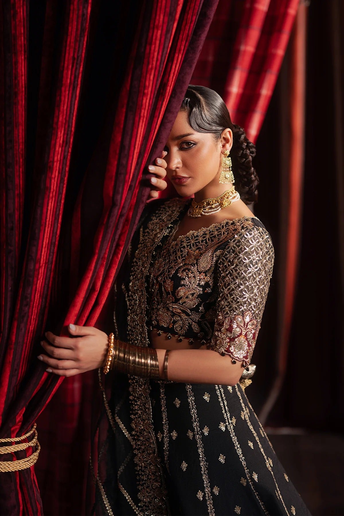 Elegant black raw silk embroidered suit featuring detailed front and back panels, organza sleeves, and a richly embroidered organza dupatta with red accents—perfect for luxury festive wear.