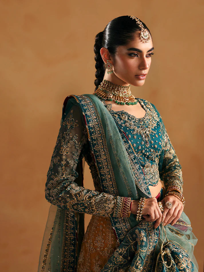 Luxury lehenga set featuring embroidered net bodice, sequined sleeves, organza panels, raw silk borders, detailed adda work, and matching embellished dupatta.