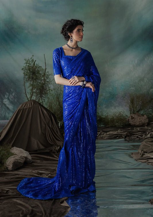 Elegant chiffon saree with embroidered fall and pallu, paired with an embroidered chiffon blouse featuring organza neckline and sleeve borders with silk petticoat.