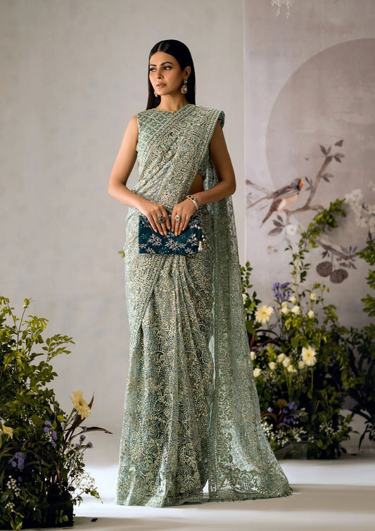 Stunning aqua tulle saree with embroidered fall and pallu, paired with a medium silk blouse featuring gold and aqua embroidery, sequins, and organza borders for festive elegance.