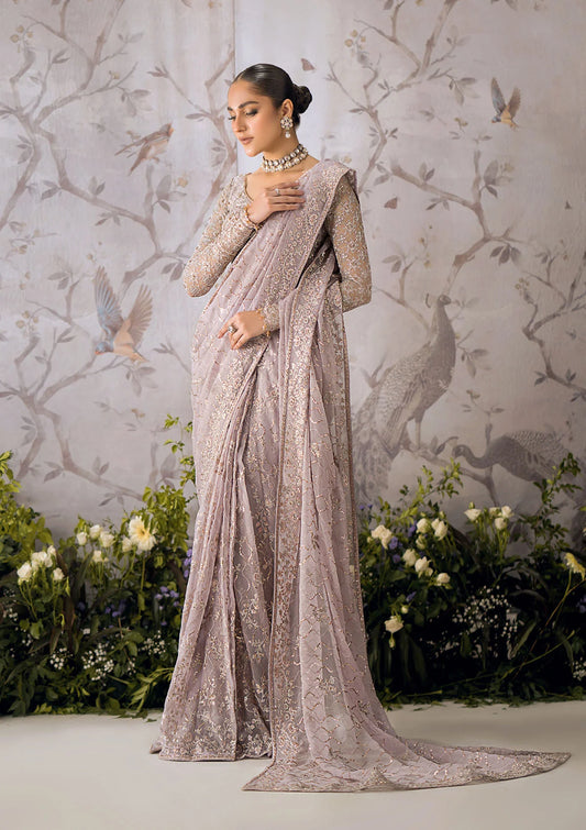 Ethereal lilac chiffon saree with self embroidered fall and pallu, paired with a net blouse adorned with silver tilla, rose gold sequins and organza borders.
