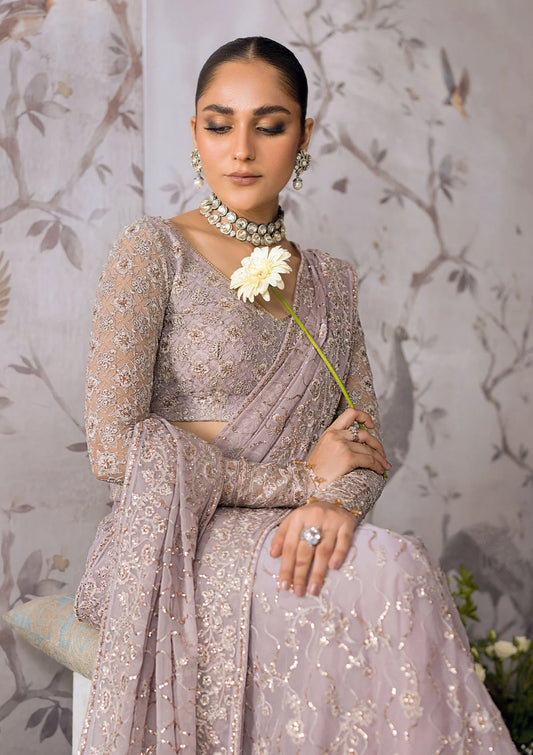 Ethereal lilac chiffon saree with self embroidered fall and pallu, paired with a net blouse adorned with silver tilla, rose gold sequins and organza borders.
