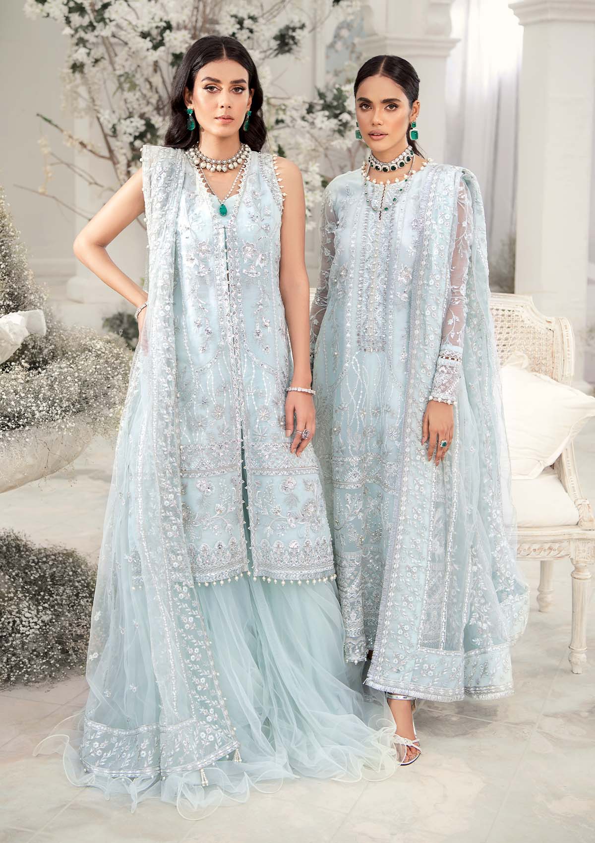 Elegant ice blue organza ensemble featuring hand embellishments, signature embroidery, silver sequins, pearl beadwork, raw silk pants, and an embroidered net dupatta for a refined pastel formal look.