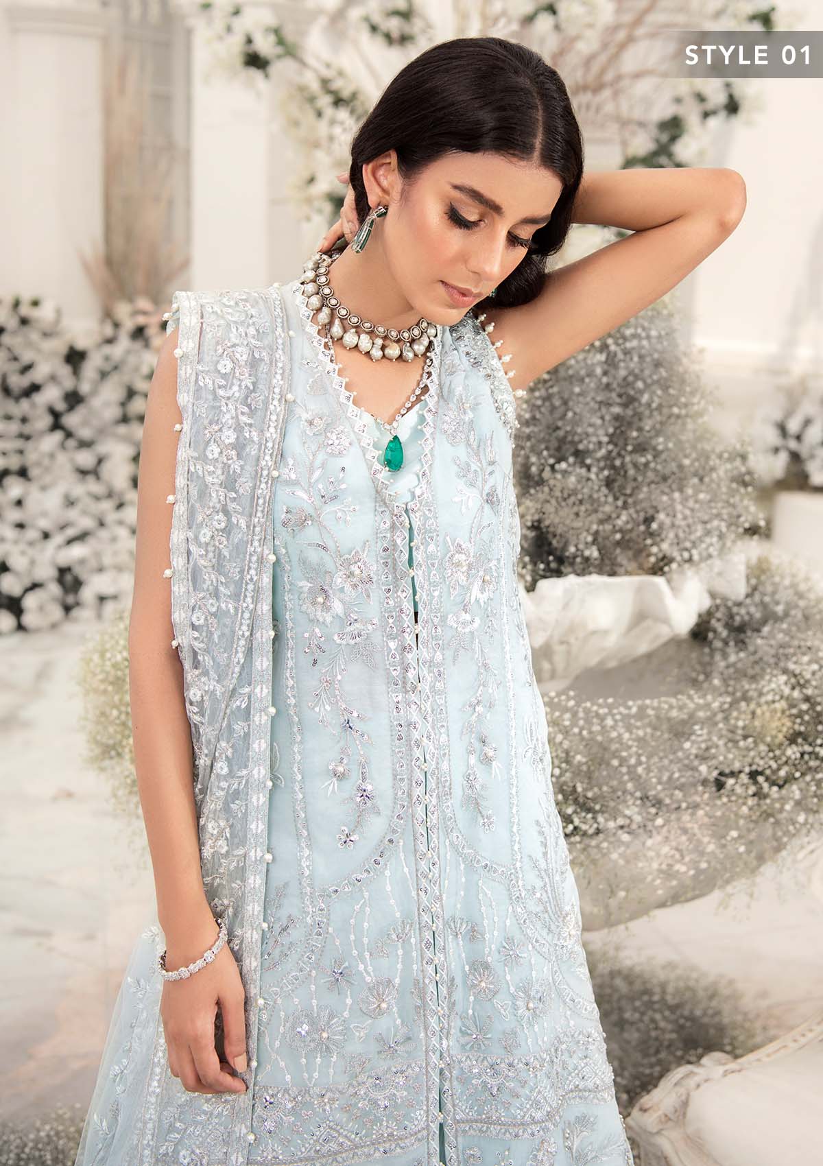 Elegant ice blue organza ensemble featuring hand embellishments, signature embroidery, silver sequins, pearl beadwork, raw silk pants, and an embroidered net dupatta for a refined pastel formal look.