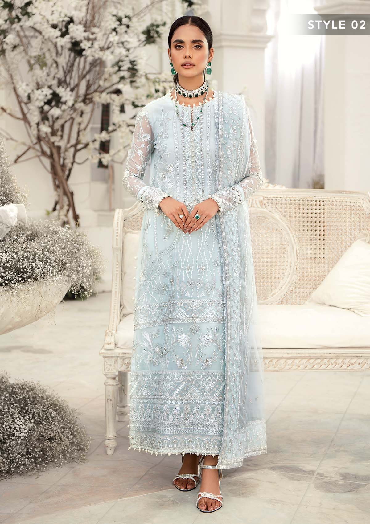 Elegant ice blue organza ensemble featuring hand embellishments, signature embroidery, silver sequins, pearl beadwork, raw silk pants, and an embroidered net dupatta for a refined pastel formal look.