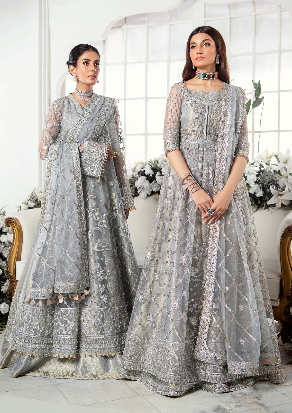Majestic silver net ensemble featuring sequin-encrusted jaals, crystal embellished details, organza borders, raw silk pants, and an embroidered net dupatta for a timeless feminine luxury look.