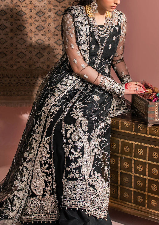 Timeless black net ensemble featuring Kashmiri paisley motifs, refined sequin and bead embellishments, organza borders, raw silk pants, and an embroidered net dupatta for elegant monochrome appeal.