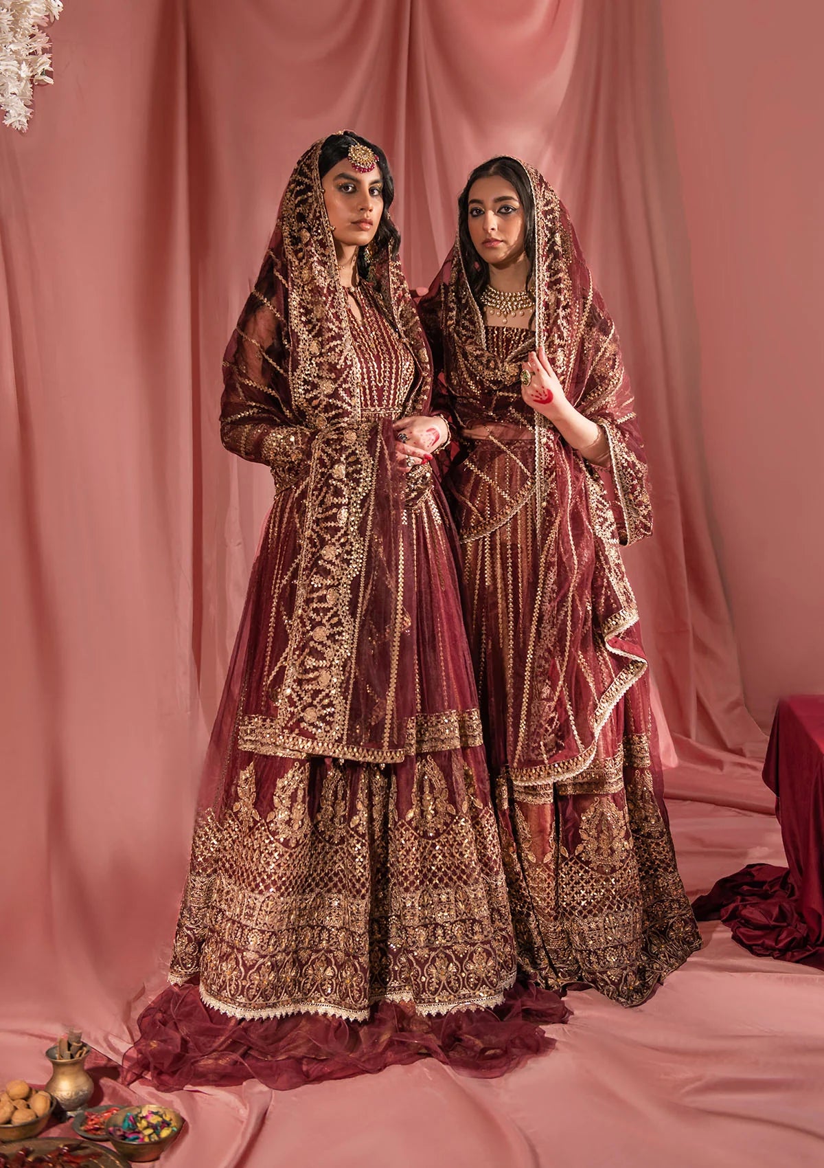 Festive mahogany net ensemble inspired by Kashmiri craftsmanship, featuring oxidised gold and bronze tilla, antique sequins, hand embellishments, masoori silk pants, and an embroidered net dupatta.