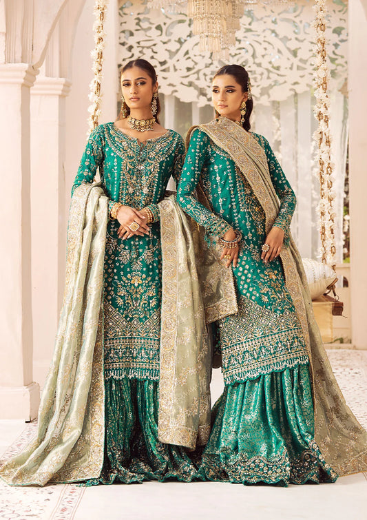 Elegant medium silk ensemble with detailed embroidery, layered borders, jamawaar pants, and a tissue dupatta. Styled as a mid-length shirt with crushed sharara or classic gharara for festive occasions.