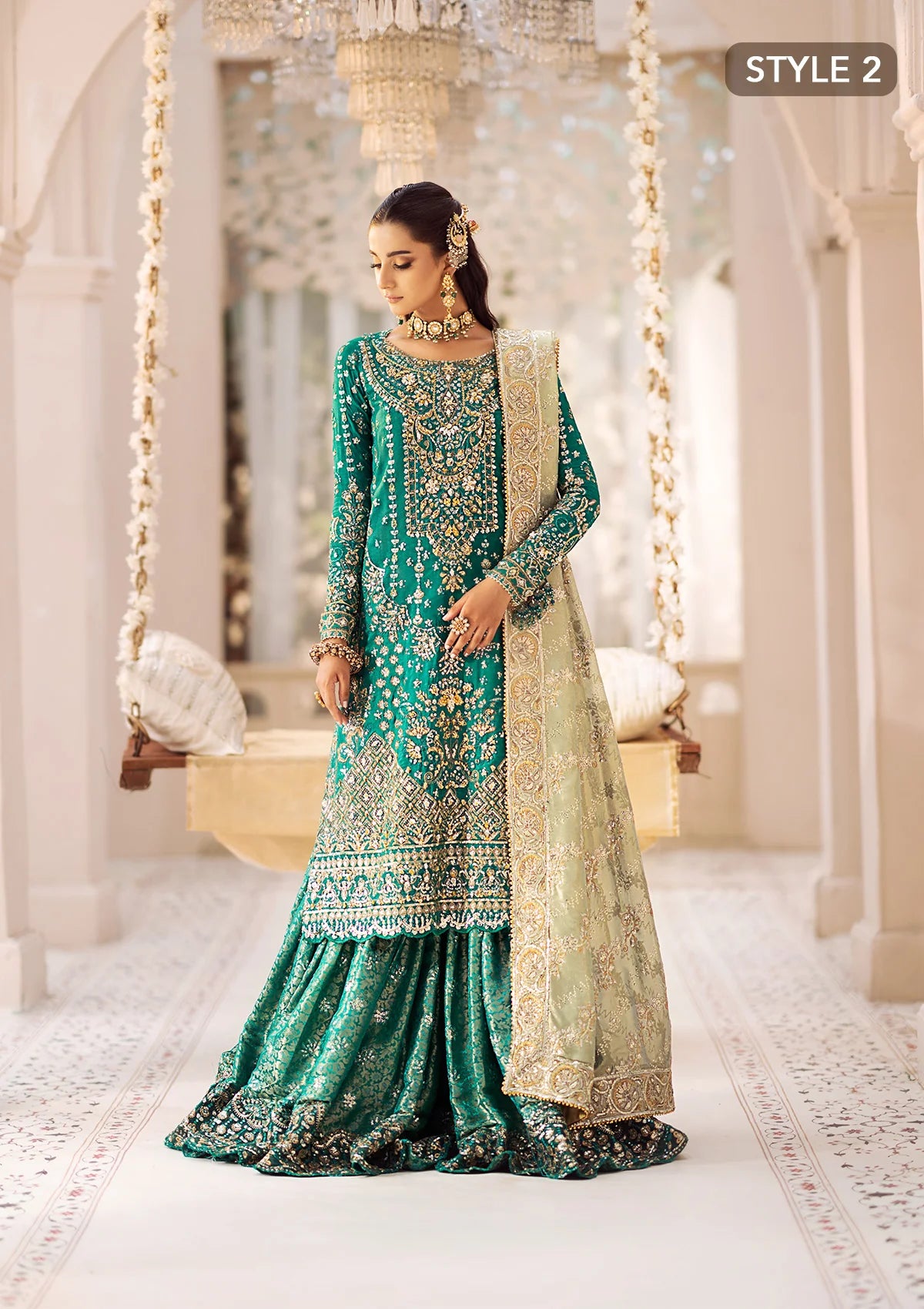 Elegant medium silk ensemble with detailed embroidery, layered borders, jamawaar pants, and a tissue dupatta. Styled as a mid-length shirt with crushed sharara or classic gharara for festive occasions.