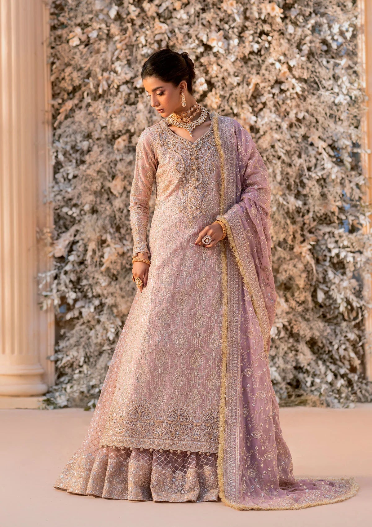 Elegant khaadi net ensemble with embellished organza neckline, detailed borders, masoori silk pants, and chiffon dupatta. Styled as angrakha with gharara or side-slit long shirt with crushed frock.