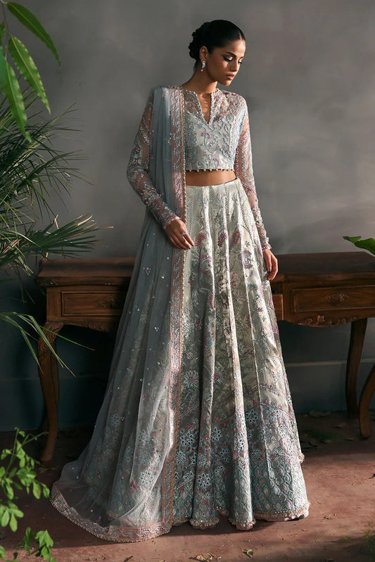 Elegant aqua net suit with embroidered panels, rose pink zari borders, and raw silk trouser for a refined festive and formal look.