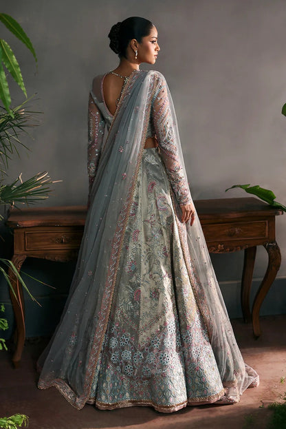 Elegant aqua net suit with embroidered panels, rose pink zari borders, and raw silk trouser for a refined festive and formal look.