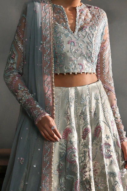 Elegant aqua net suit with embroidered panels, rose pink zari borders, and raw silk trouser for a refined festive and formal look.