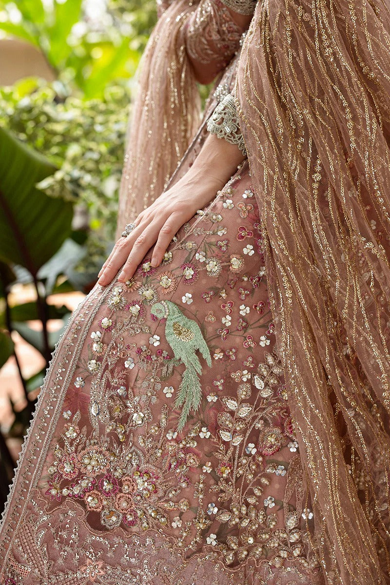 Elegant coral pink lehenga with embroidered net shirt, sequined dupatta, hand embellishments, and handmade tassels for a luxurious festive look.