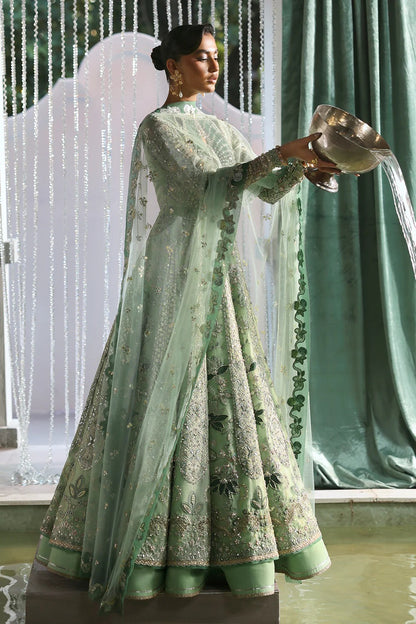 Elegant mint green silk suit featuring embroidered organza panels, velvet neck patch, net dupatta, and silk trousers. 