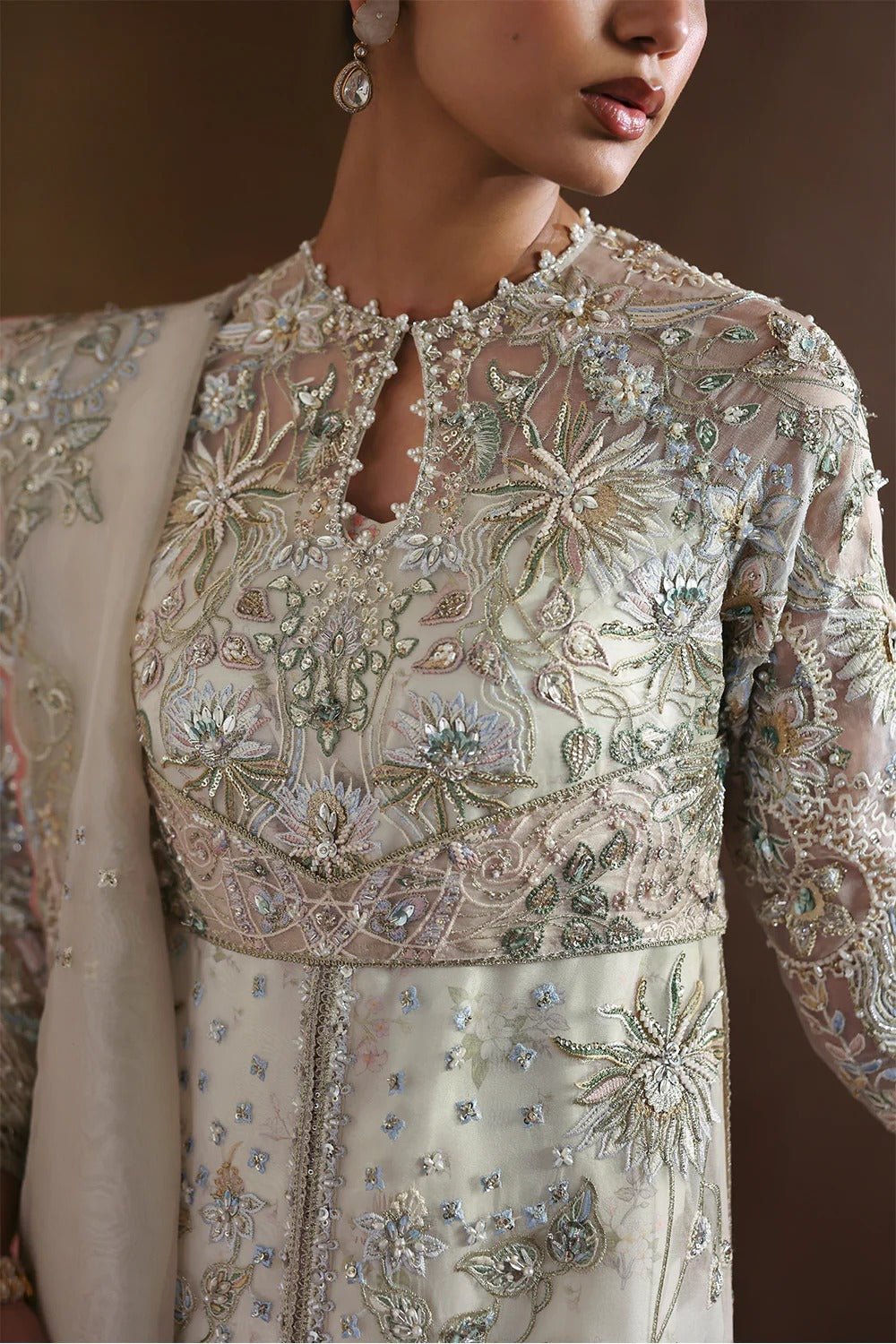 Elegant Opal White suit with embroidered organza panels, hand embellishments, silk trouser, and organza dupatta with delicate motifs.