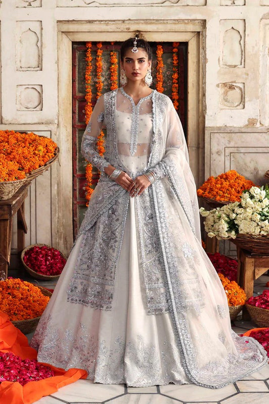 An elegant organza ensemble featuring hand-embellished panels, neckline, and sleeves. Paired with an embroidered dupatta and raw silk lehenga for a regal look.