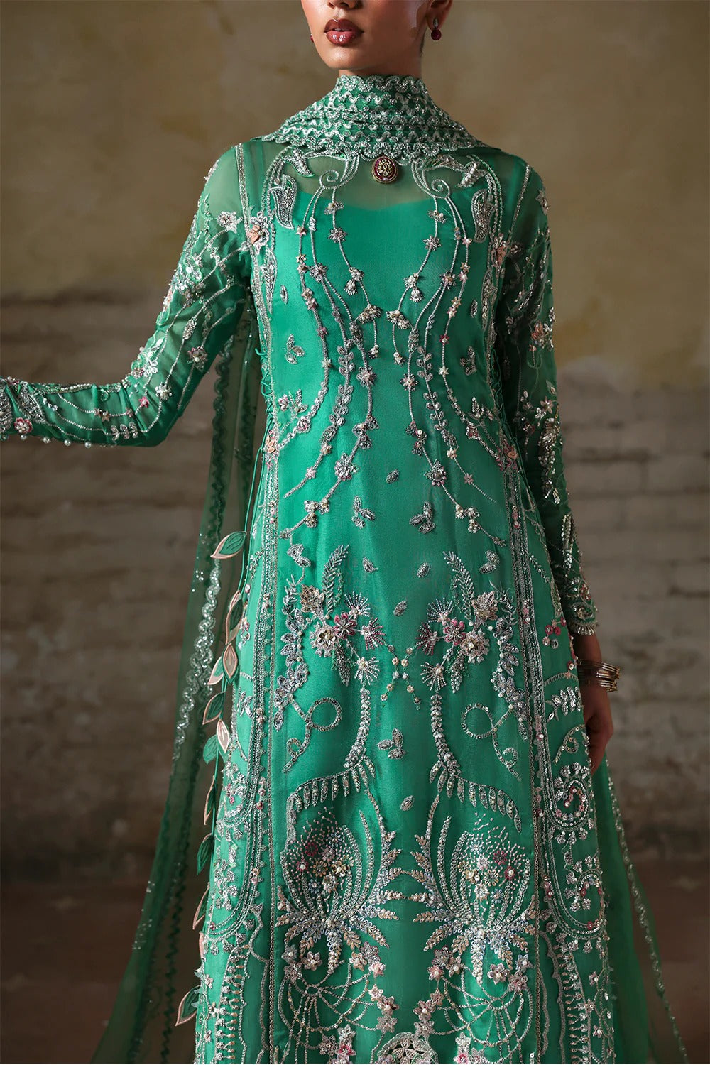 Shop this elegant Mazari Green unstitched suit with embroidered organza panels, hand embellishments, 3D floral details, silk trouser & net dupatta.