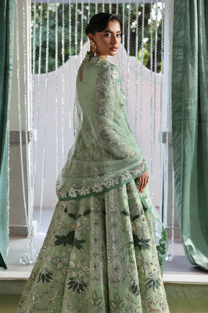 Elegant mint green silk suit featuring embroidered organza panels, velvet neck patch, net dupatta, and silk trousers. 