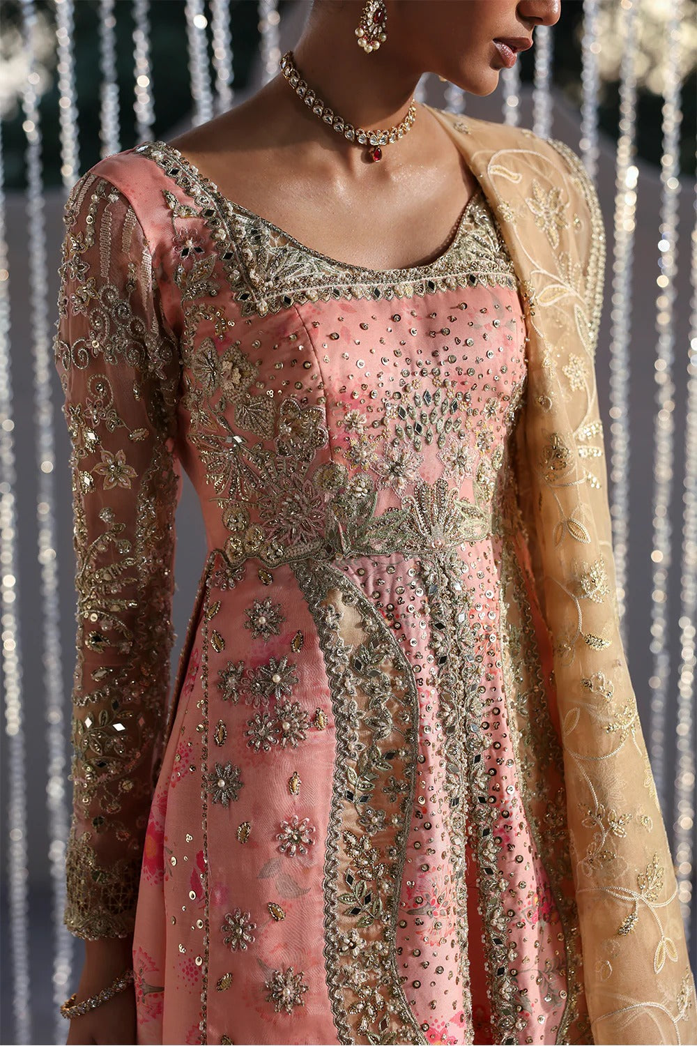 Beautiful printed pink silk suit with embroidered organza panels, embellished dupatta, and stylish sharara. Perfect for weddings, festive, and formal occasions.