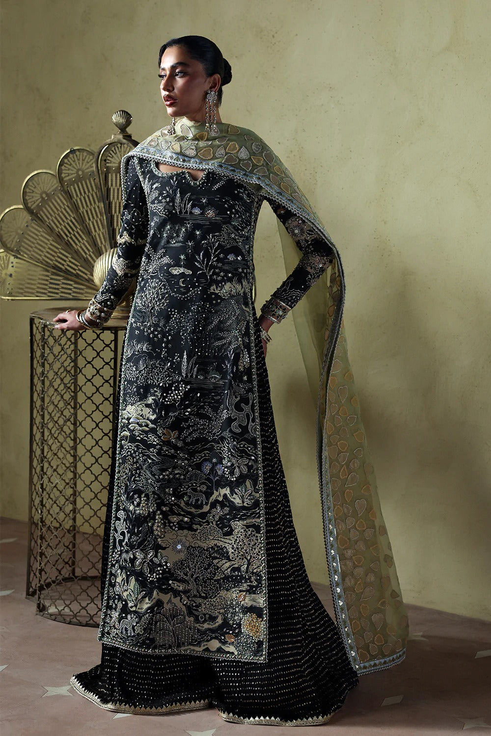 Stylish black silk suit featuring hand-embellished panels, embroidered dupatta, and chiffon crushed trousers. Perfect choice for festive and formal occasions.