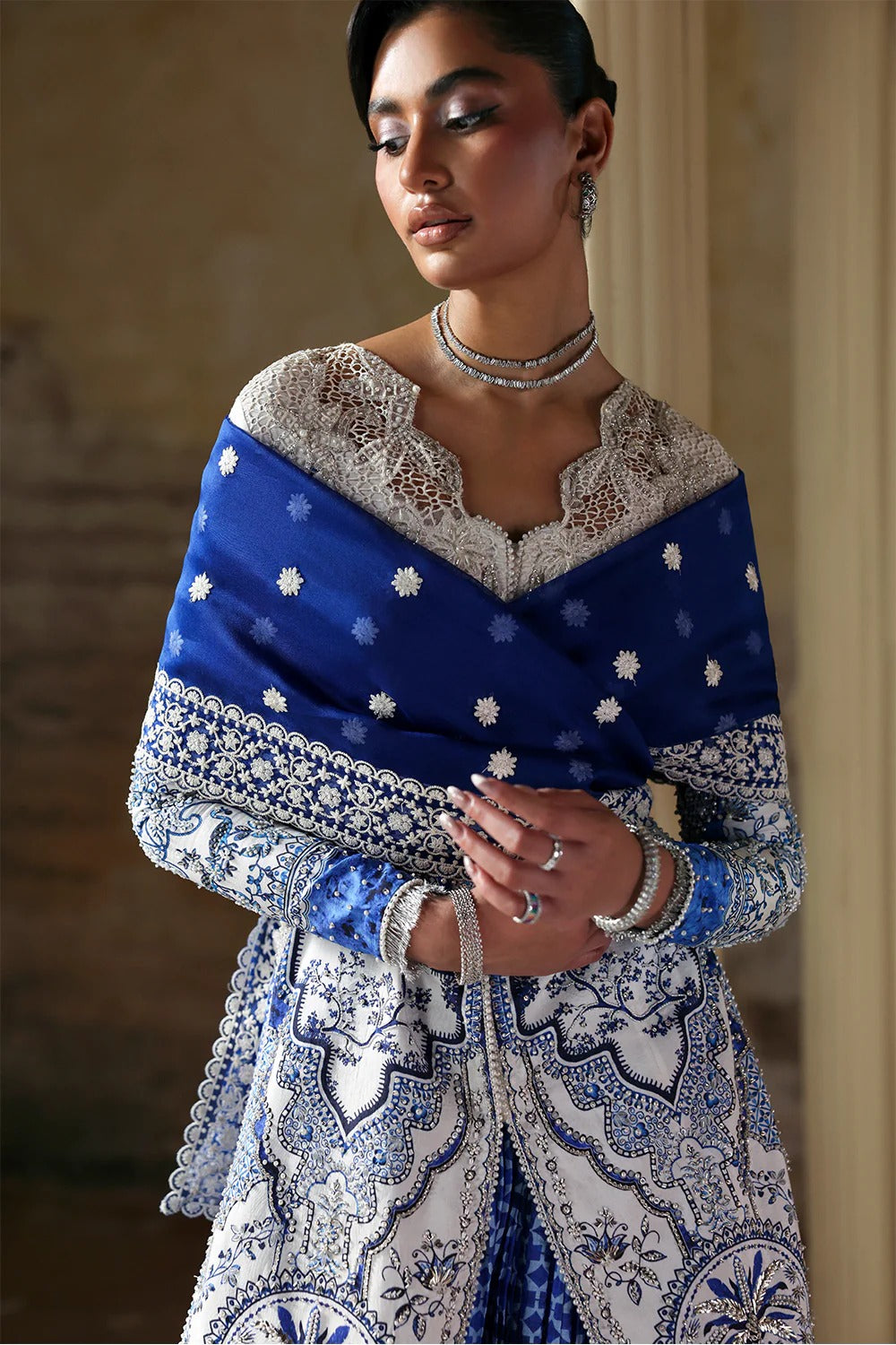 Elegant white blue printed silk suit with hand-embellished panels, embroidered dupatta,&   crushed sharara. Perfect for weddings, festive, and formal occasions.