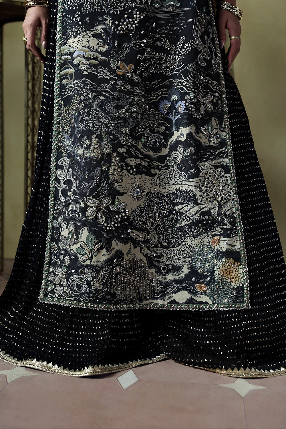 Stylish black silk suit featuring hand-embellished panels, embroidered dupatta, and chiffon crushed trousers. Perfect choice for festive and formal occasions.