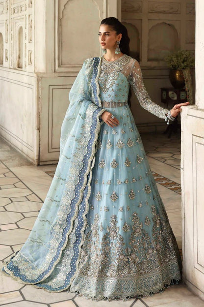 An elegant net dress with hand-embellished panels, sleeves, and blouse. Paired with an embroidered organza dupatta and raw silk inner for a timeless look.