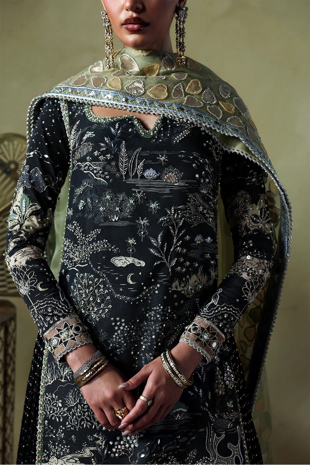Stylish black silk suit featuring hand-embellished panels, embroidered dupatta, and chiffon crushed trousers. Perfect choice for festive and formal occasions.