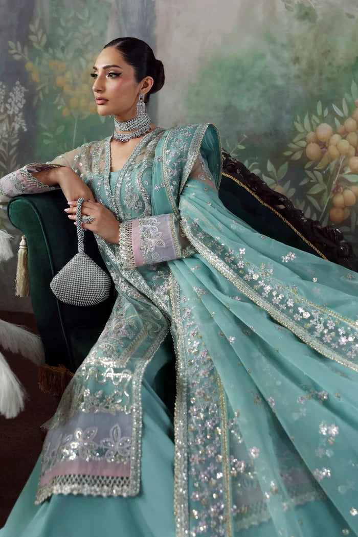Chic net & organza suit with embroidered panels, sleeves, dupatta & borders, paired with silk inner and trouser—crafted for elegance & timeless style.