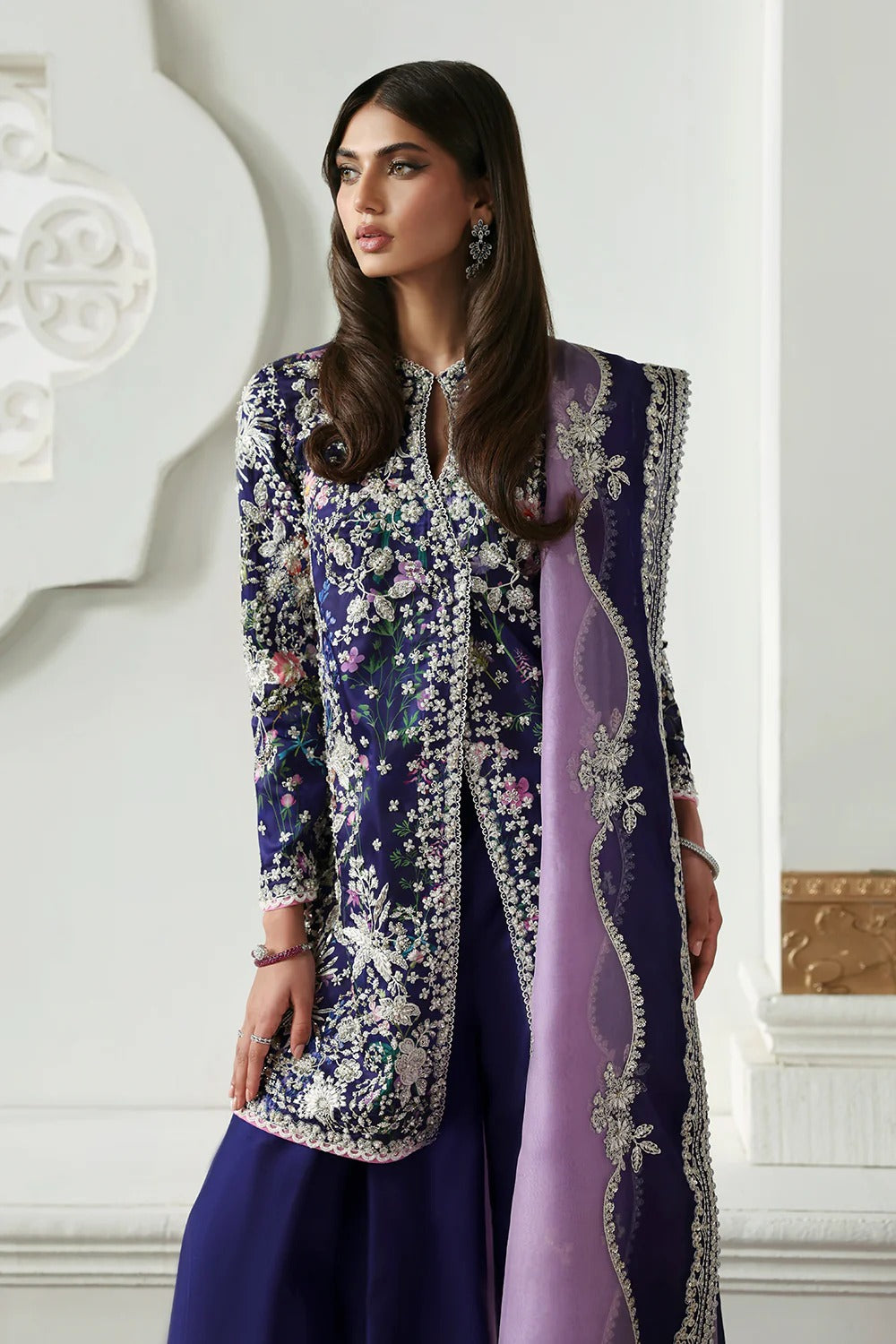 Elegant floral printed purple silk suit with embroidered panels, embellished organza dupatta, and matching silk trousers. A perfect outfit for festive & formal occasions.