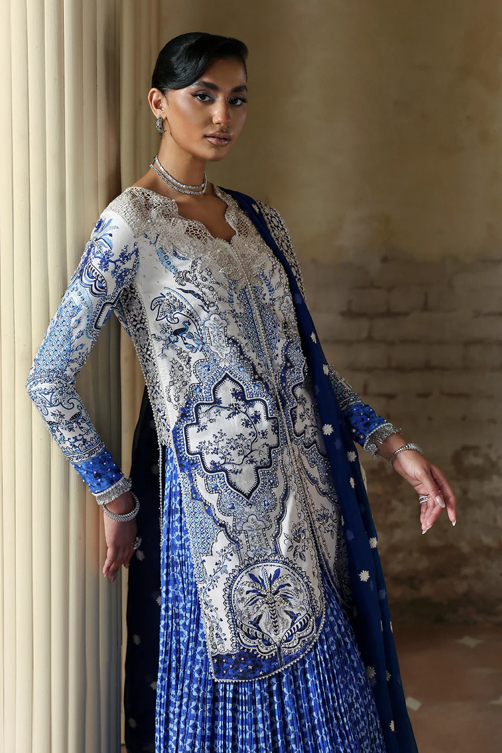 Elegant white blue printed silk suit with hand-embellished panels, embroidered dupatta,&   crushed sharara. Perfect for weddings, festive, and formal occasions.