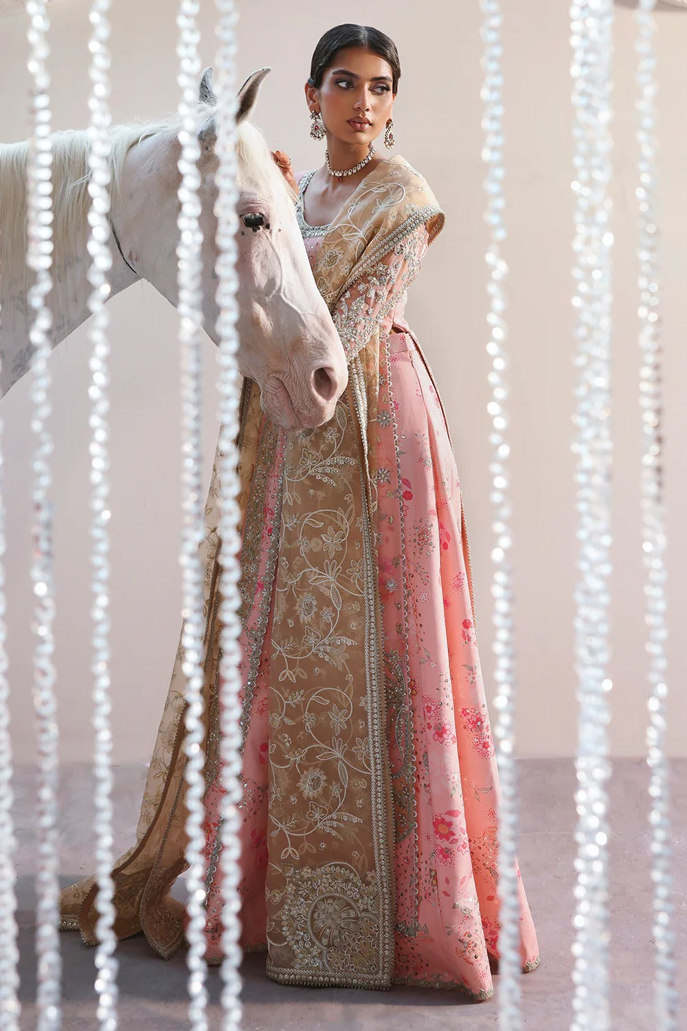Beautiful printed pink silk suit with embroidered organza panels, embellished dupatta, and stylish sharara. Perfect for weddings, festive, and formal occasions.