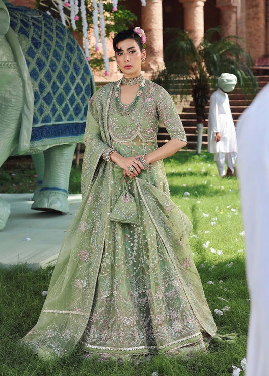 Elevate your festive look with this sage green zari organza outfit featuring delicate hand embroidery, printed raw silk trousers, and an elegant dupatta.