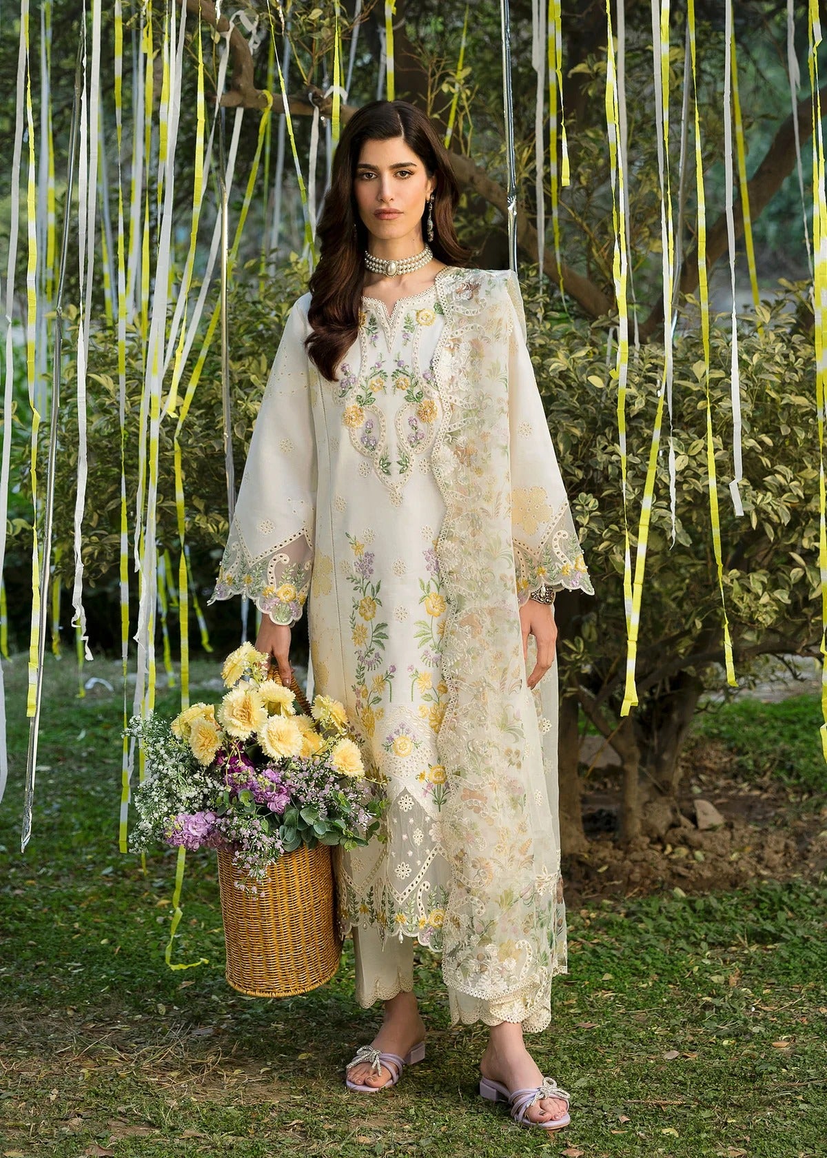 Look elegant in this ivory embroidered lawn suit with chikan-kari panels, hand-work neckline, woven net dupatta, and cotton trouser for a timeless style.