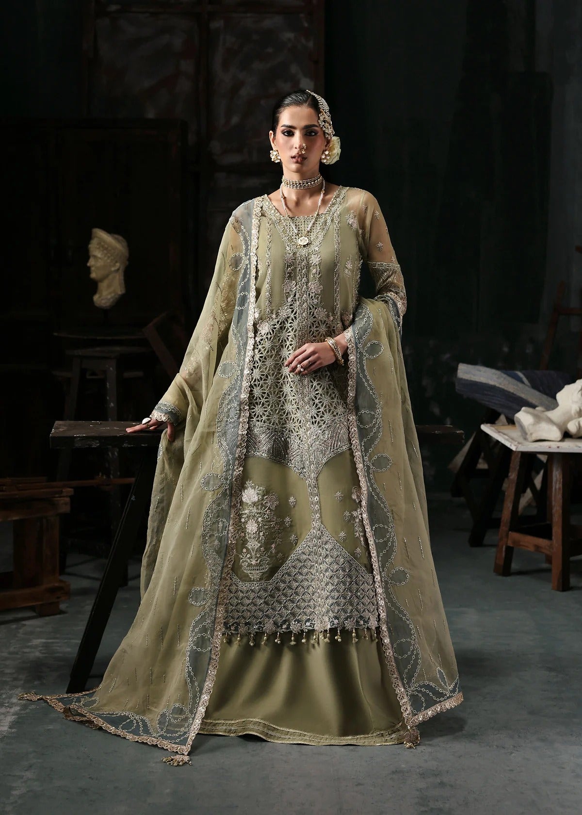 Graceful olive green organza suit with dori work, cutwork neckline, embroidered dupatta, and raw silk trouser a perfect choice for festive elegance.