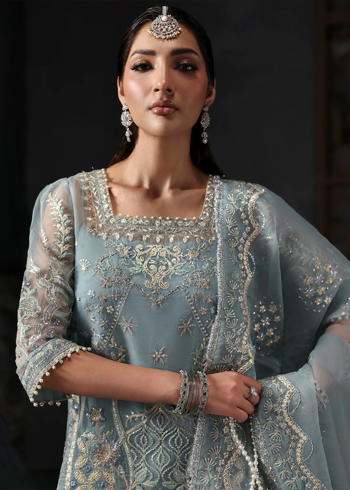 Chic ice blue organza dress with embroidered panels, dupatta & raw silk trouser. Available stitched/unstitch with custom sizing & worldwide delivery.