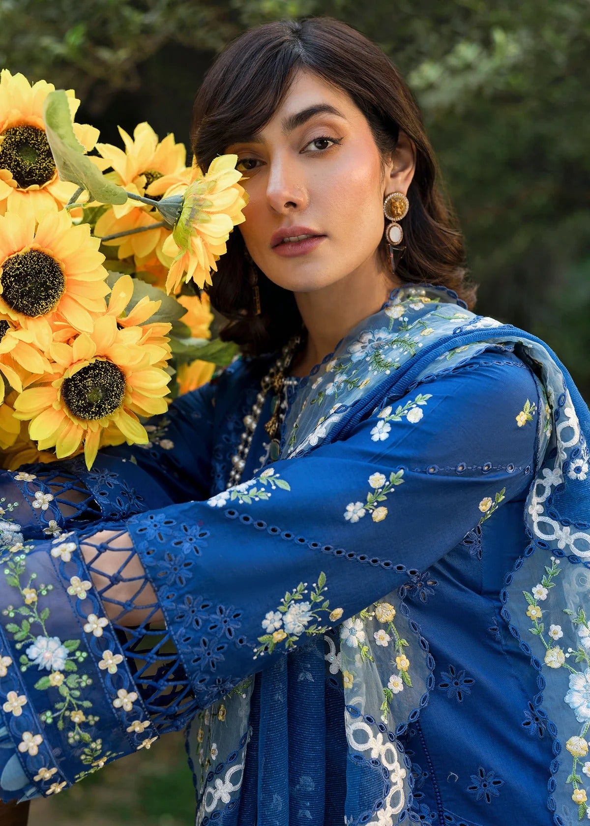 Step into elegance with this blue embroidered lawn suit featuring chikan-kari panels, hand-work neckline, net dupatta, and cotton trouser.