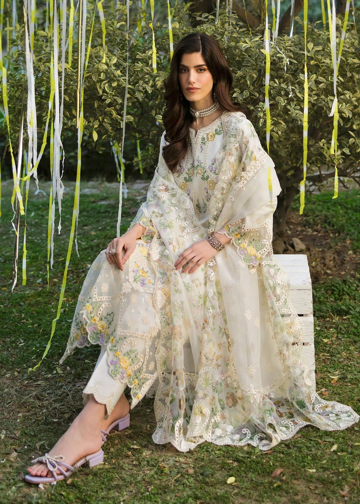 Look elegant in this ivory embroidered lawn suit with chikan-kari panels, hand-work neckline, woven net dupatta, and cotton trouser for a timeless style.